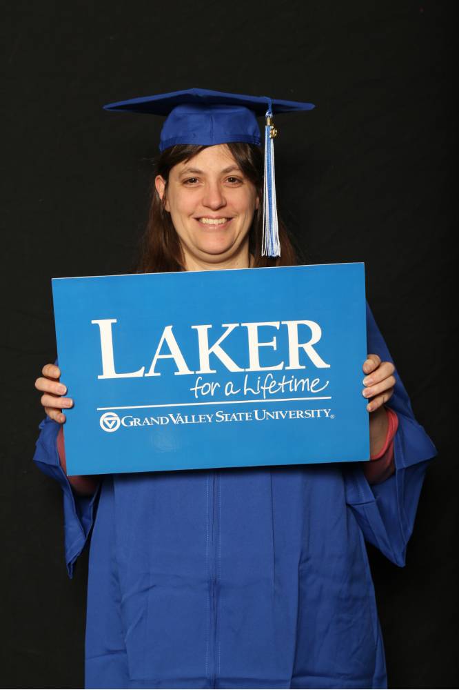 holding sign that says laker for a lifetime GVSU